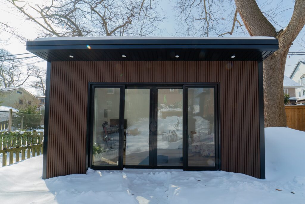 Custom garden building in a backyard, designed to enhance outdoor space with functionality and style for various uses such as office, storage, or relaxation.