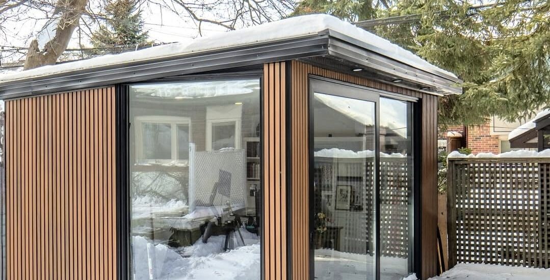 Modern garden room with large windows, seamlessly blending with the outdoor space and offering a stylish, functional retreat
