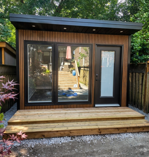 Custom-built modern garden office in Toronto with wood-look siding, large windows and glass door