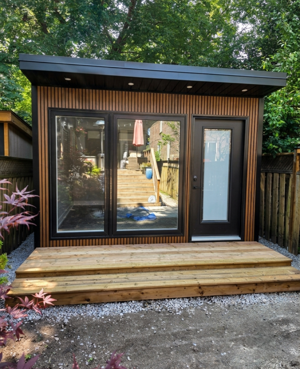 Custom-built modern garden office in Toronto with wood-look siding, large windows and glass door